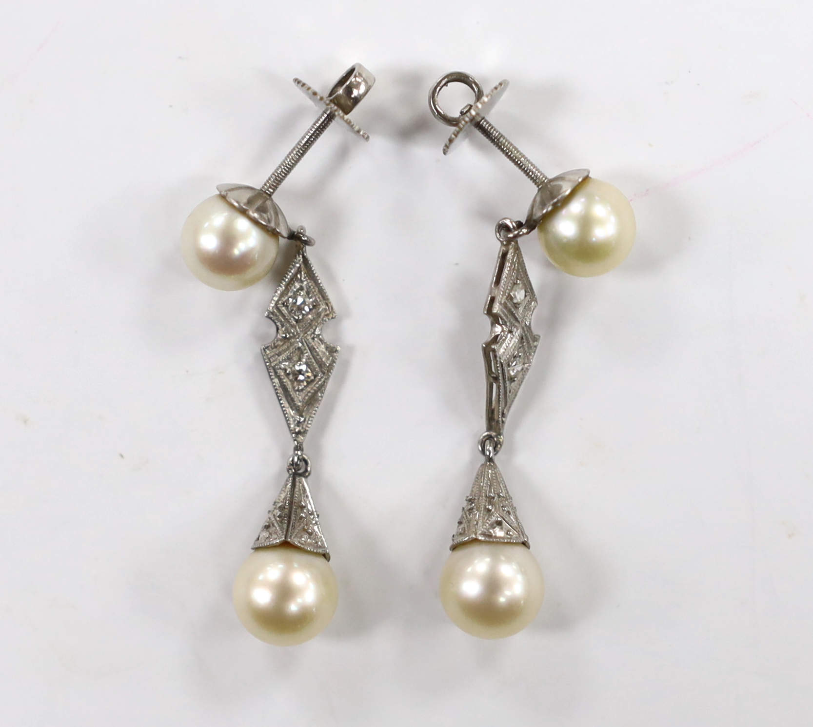 A pair of white metal, two stone cultured pearl and two stone diamond chip set drop earrings, 37mm, gross weight 6.1 grams.